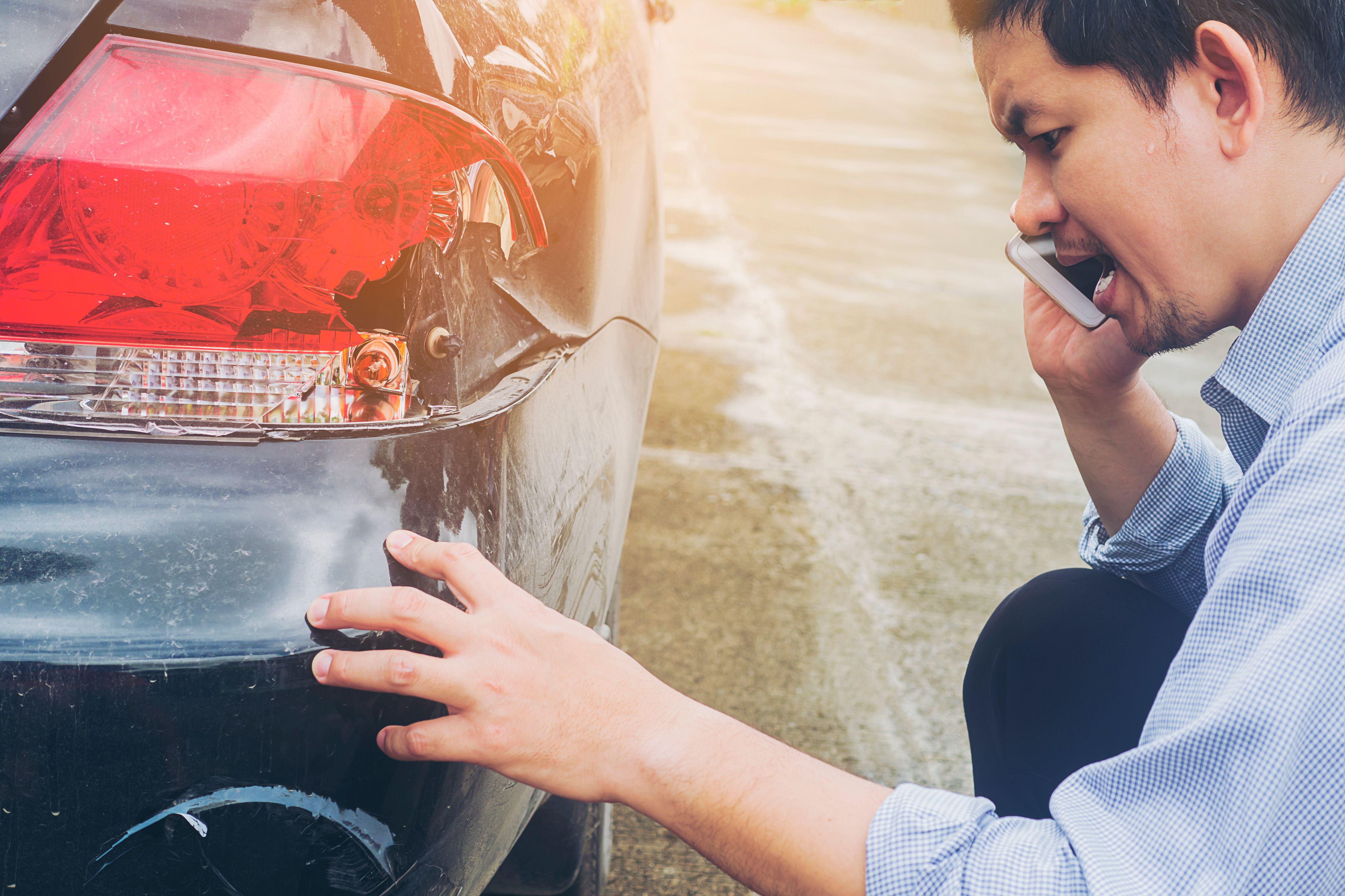 man-is-calling-insurrance-company-claiming-his-car-crash-damaged-road-accident.jpg